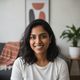 Portrait of a smiling young South Asian woman, headshot, looking at the camera with a warm and trustworthy expression.